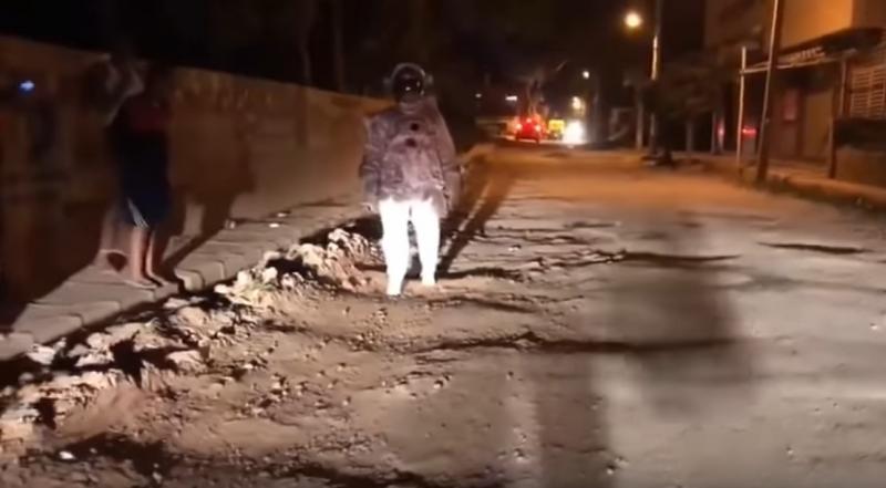 Gropile din asfalt au devenit cratere similare cu cele de pe Lună. Un „astronaut” se luptă cu gravitația pe străzile orașului explorând gropile