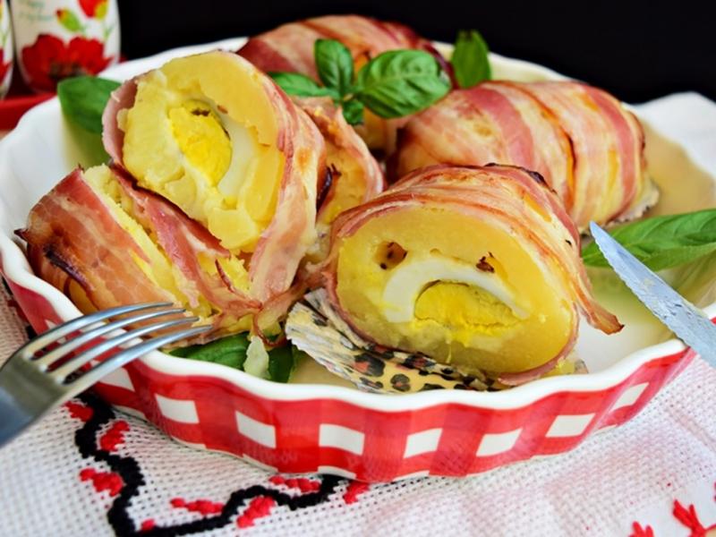 Ce mai pregătim pentru un prânz gustos și sățios? O interesantă Rețeta Cartofi în crustă de bacon umpluți cu ouă fierte și brânzeturi