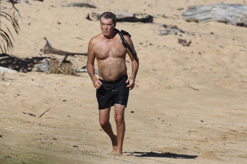 Pierce Brosnan, surprins la bustul gol pe plajă, purtând pe umăr echipamentul de scufundări