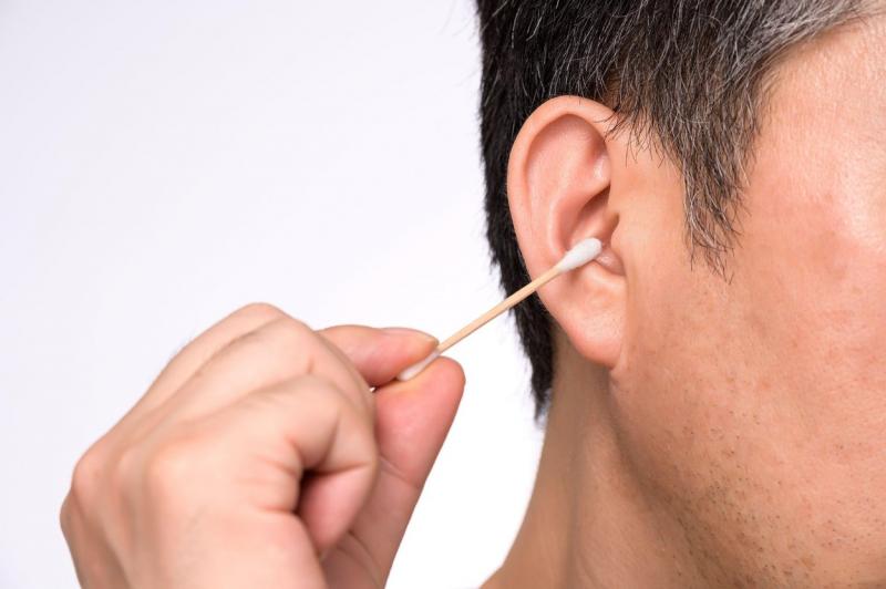 barbat care foloseste un betisor de urechi