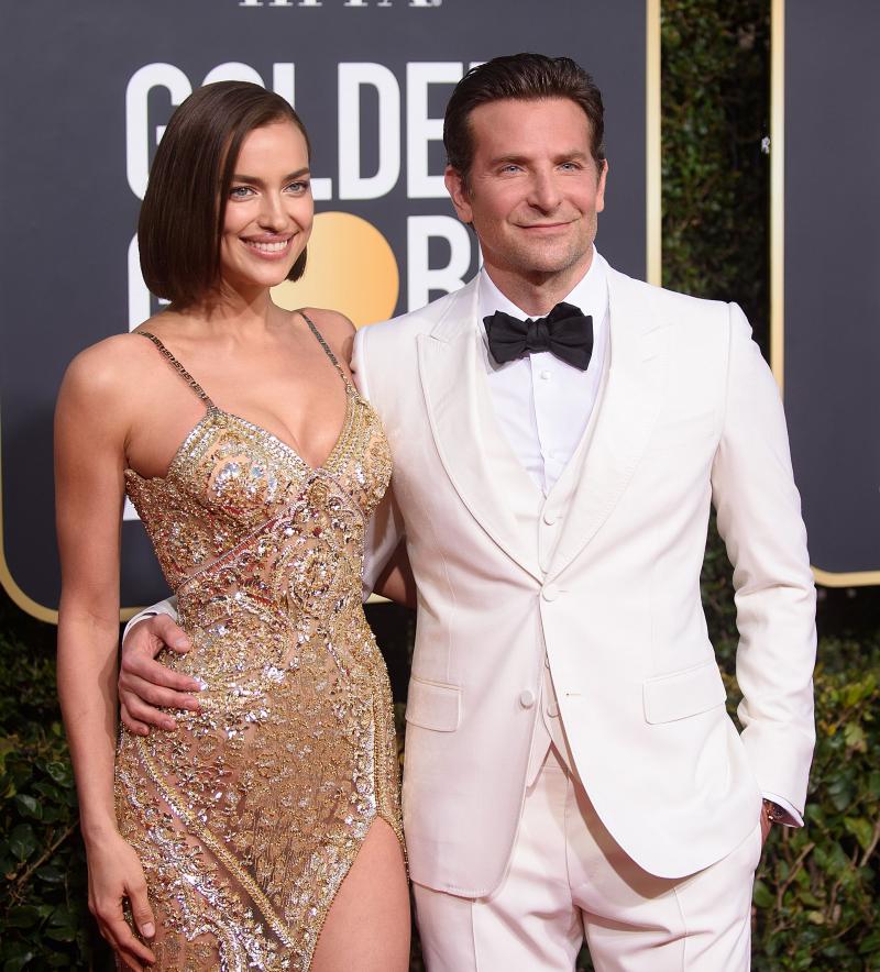 irina shayk si bradley cooper pozeaza pe covorul rosu de la globurile de aur imbracati in rochie de seara si costum alb