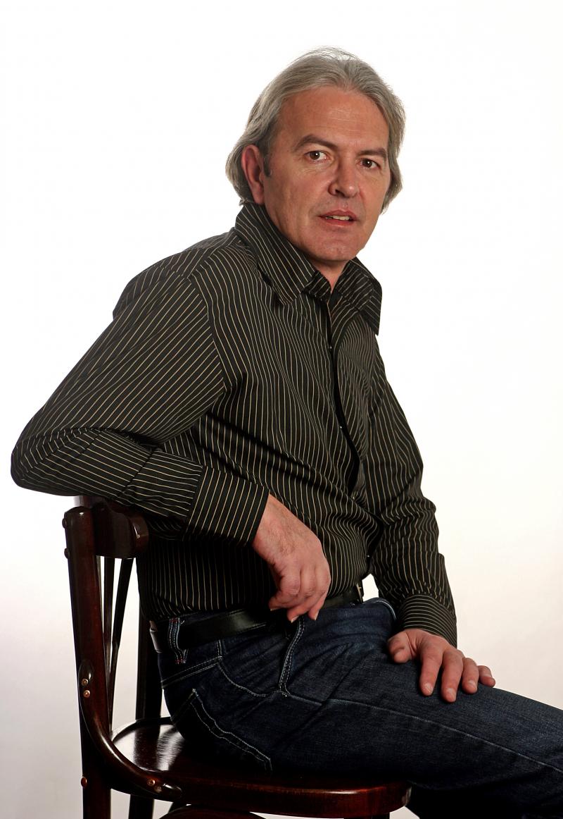 ducu bertzi in camasa neagra stand pe un scaun