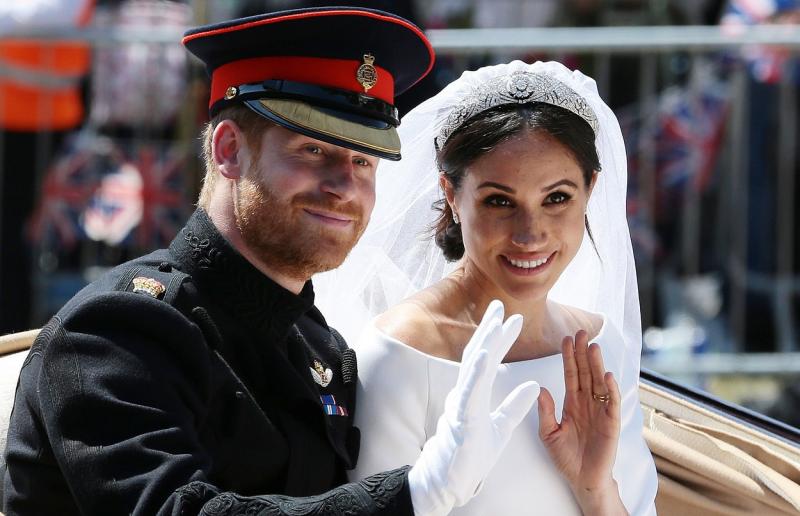 Prințul Harry și Meghan Markle salutând din trăsură persoanele care au venit să îi vadă în ziua nunții