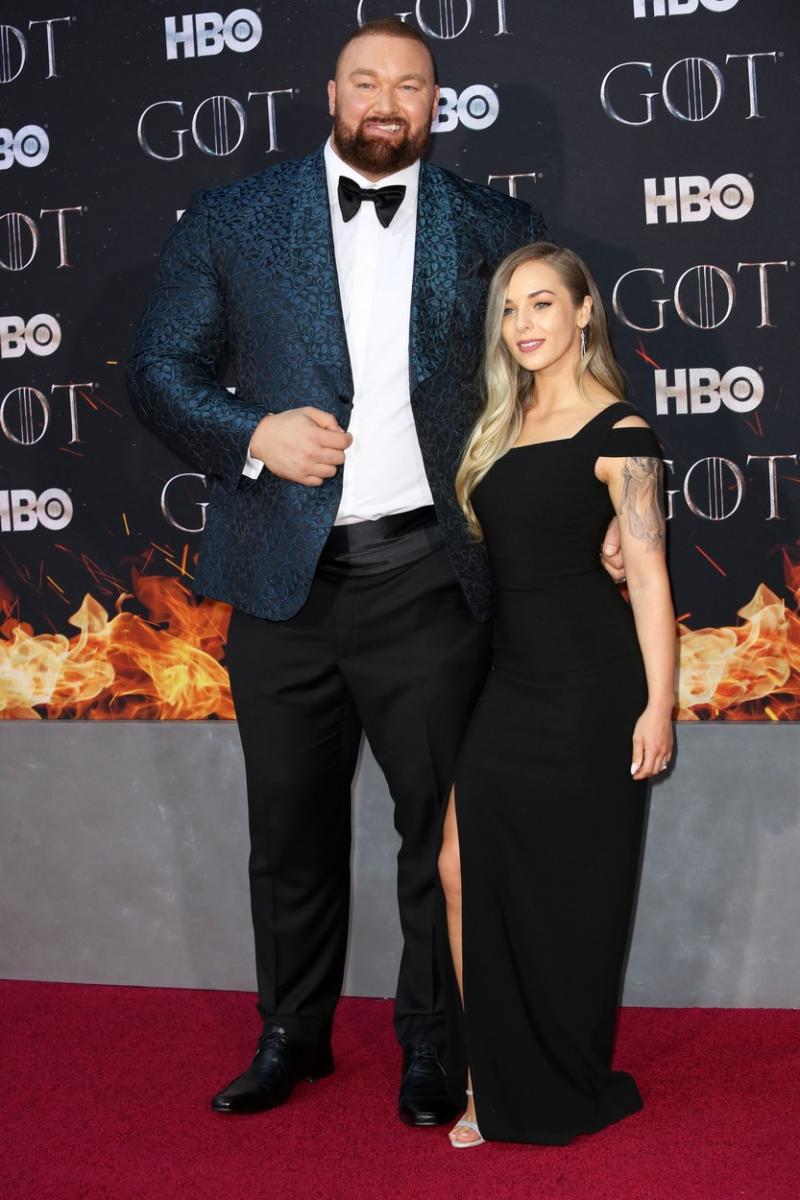 the mountain din game of thrones pe covorul rosu, imbracat la costum alaturi de sotia sa intr-o rochie neagra