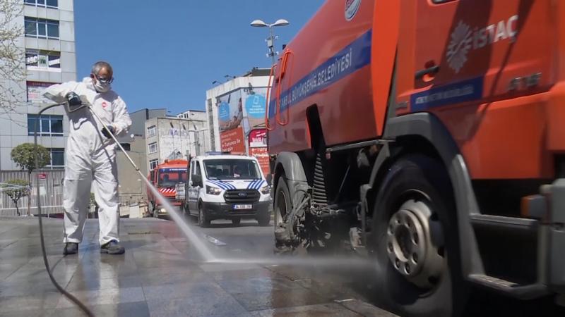 Angajat dezinfectează un trotuar din orașul Istanbul