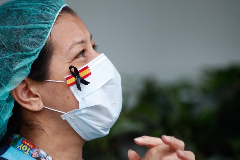 Asistentă medicală cu steagul Spaniei la mască