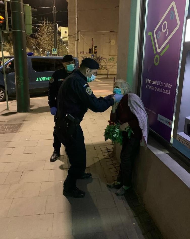 Bătrâna primește o mască de protecție de la jandarmi