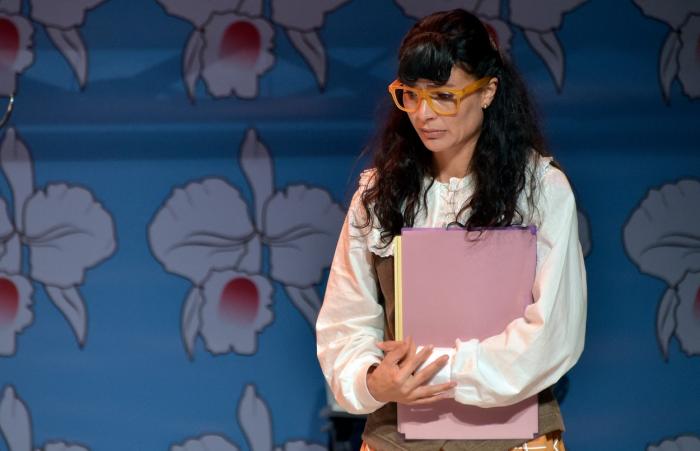 Ana Maria Orozco poartă părul desprins și are breton. Are o cămașă albă