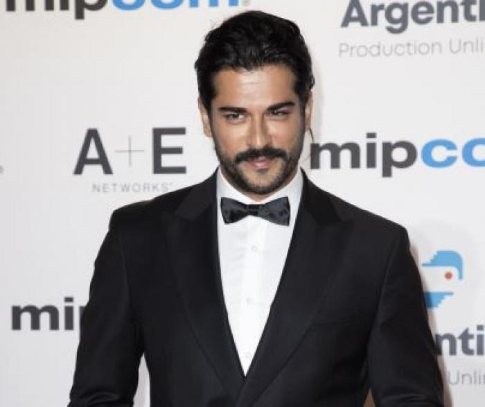 Burak Ozcivit poartă un costum negru și o cămașă albă