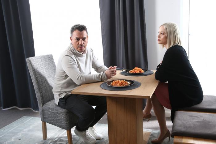 Răzvan Fodor poartă pantaloni închiși la culoare și un pulover pe gât