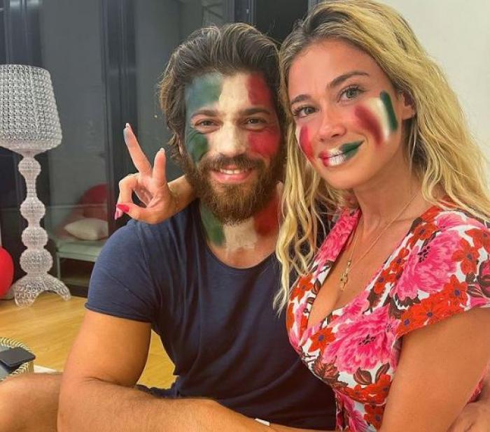 Can Yaman poartă un tricou albastru și Diletta Leotta poartă o rochie cu flori