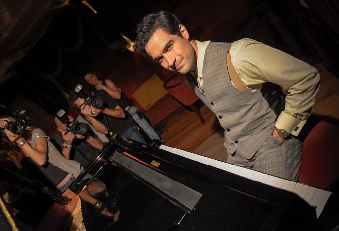 Alfonso Herrera poartă un costum gri cu sacou și o cămașă cu mânecă lungă