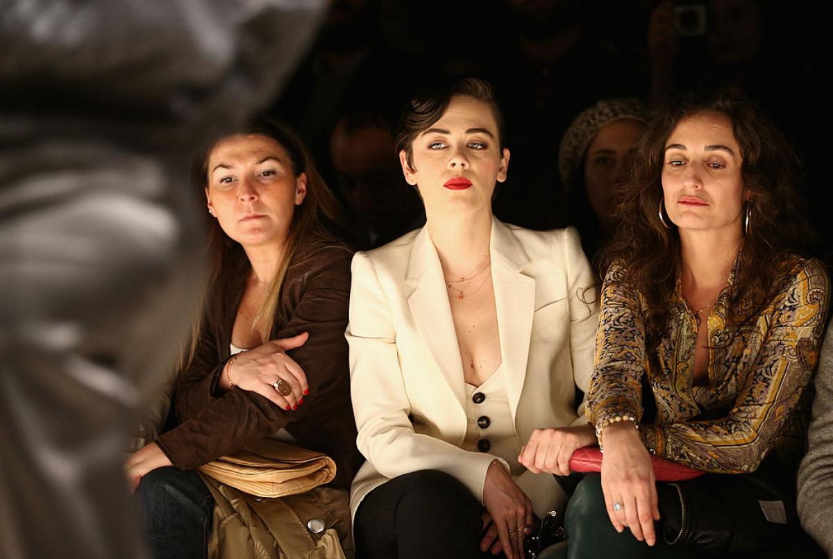 Demet Evgar poartă sacou alb și are părul prins. Actrița poartă un ruj roșu