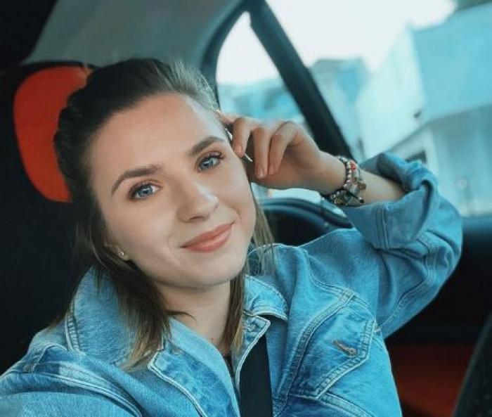 Cristina Ciobănașu are părul prins lejer, poartă o geacă de blugi și se află în mașină