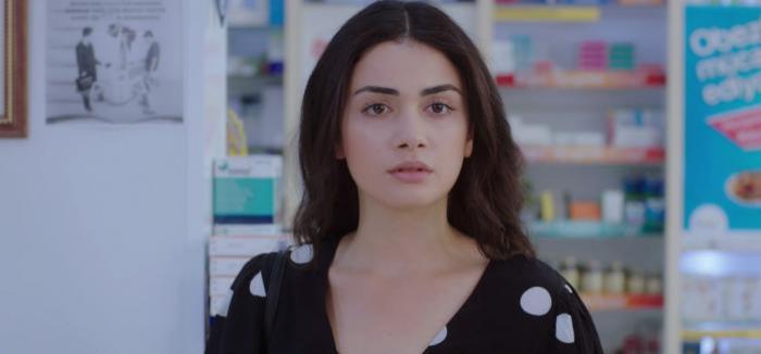 Ozge Yagiz poartă o bluză neagră cu picățele albe