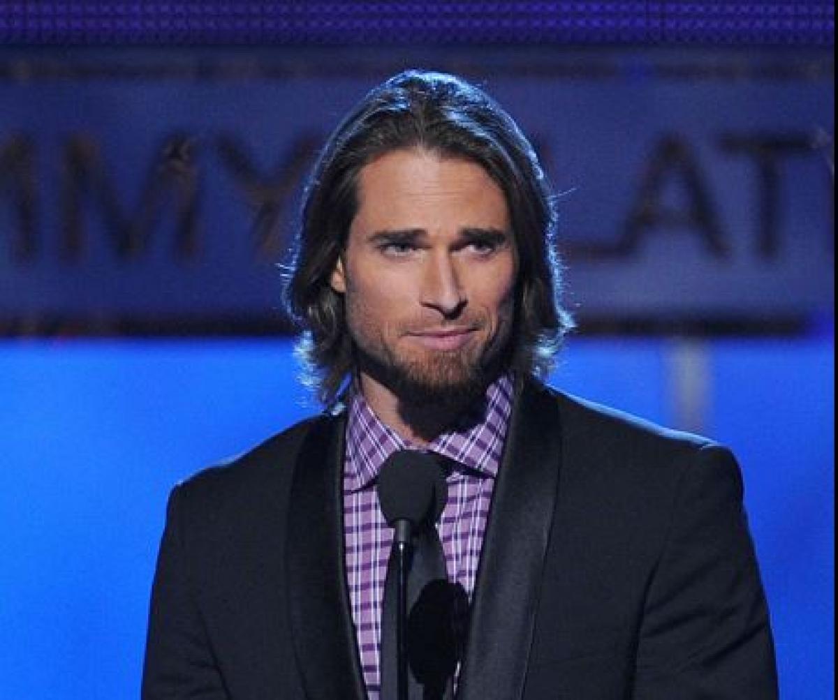 Sebastian Rulli poartă o cămașă mov și un sacou închis la culoare