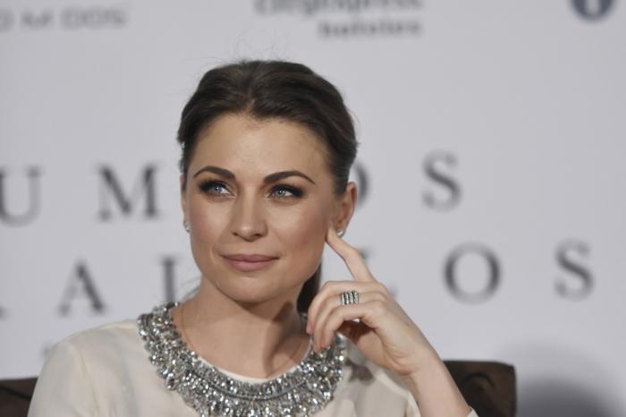 Ludwika Paleta poartă părul prins și își ține degetul arătător pe obraz