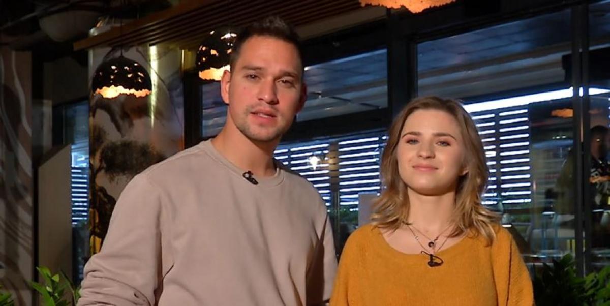 Cristina Ciobănașu poartă o bluză galben muștar și Vlad German poartă o bluză gri