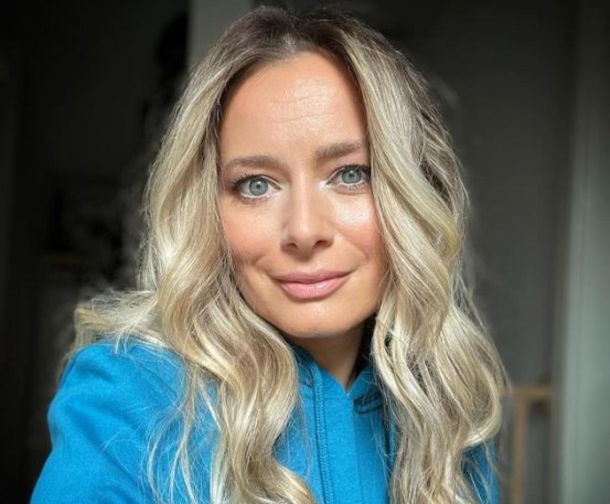 Laura Cosoi este îmbrăcată în albastru și are părul desprins și ondulat