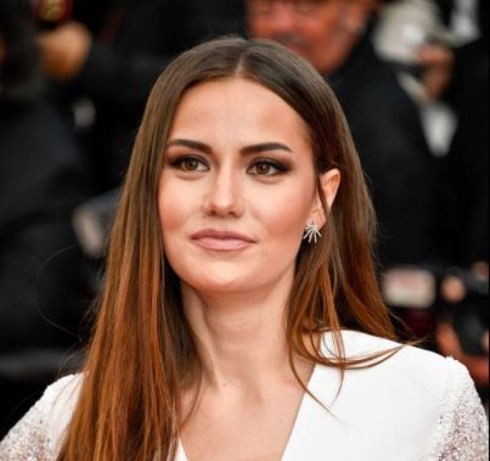 Fahriye Evcen Ozcivit poartă o rochie albă și are părul desprins