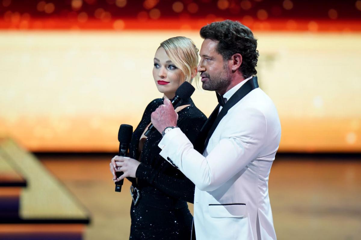 Gabriel Soto poartă un costum alb, iar Irina Baeva unul negru