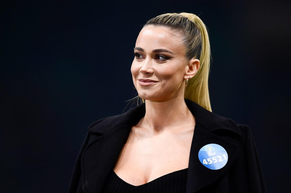 Diletta Leotta poartă un top negru și un sacou de aceeași culoare. Are părul prins într-o coadă de cal