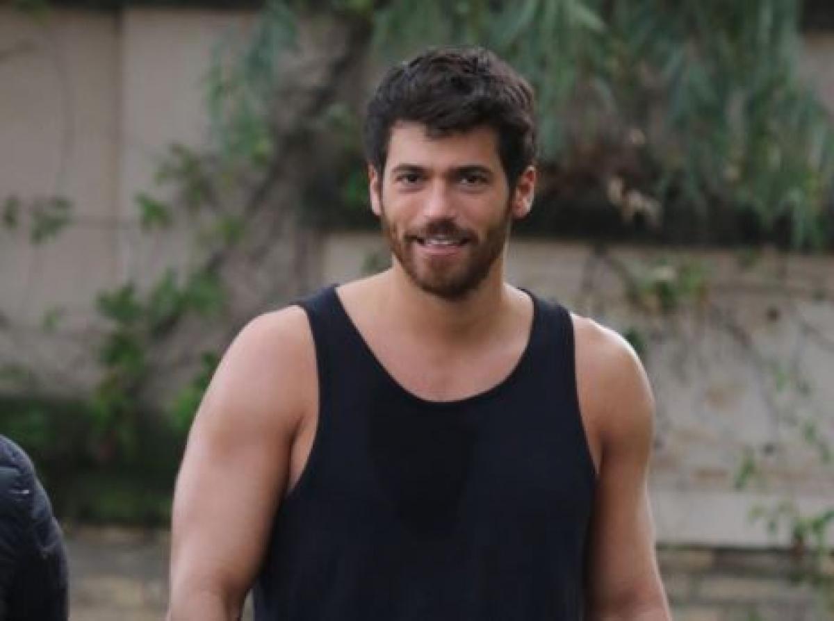 Can Yaman poartă un maiou negru și are părul scurt