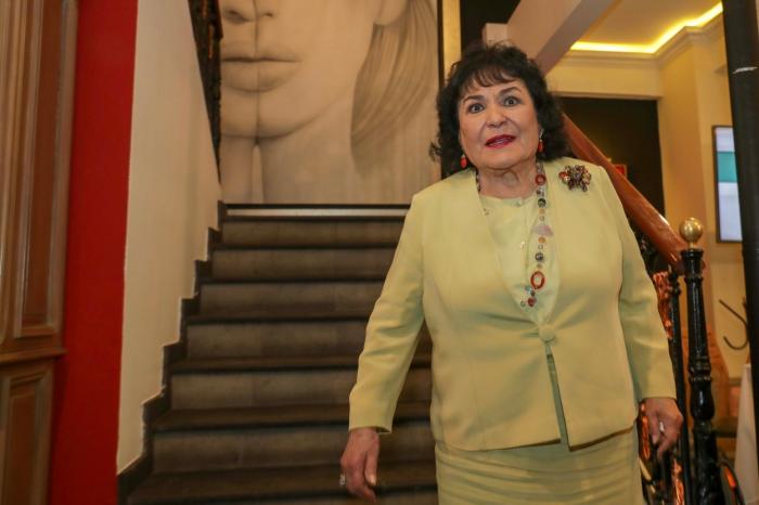 Carmen Salinas poartă un costum verde deschis și are un colier la gât
