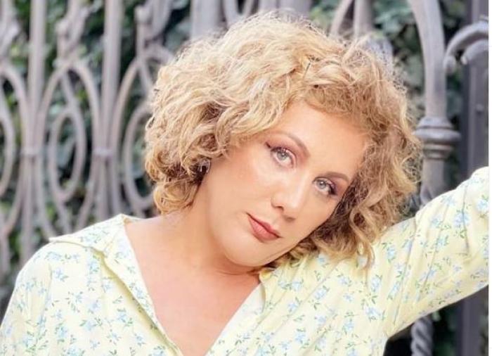 Luminița Erga poartă o bluză cu flori și are un machiaj discret