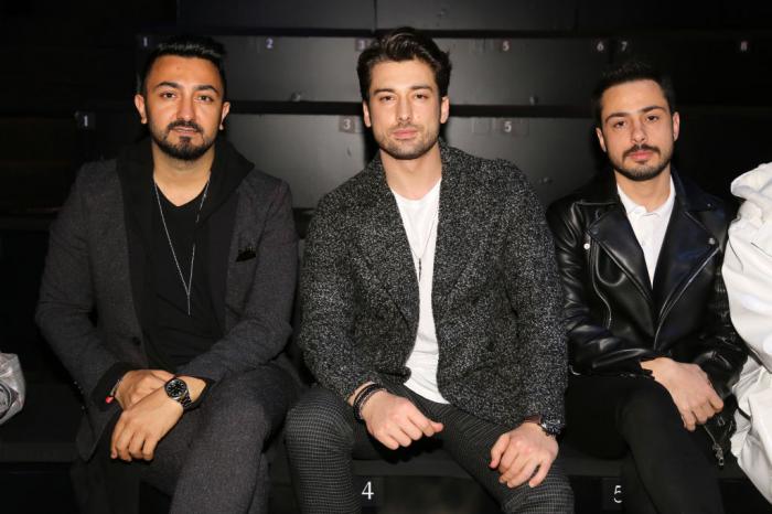 Alp Navruz poartă un tricou alb și un sacou gri