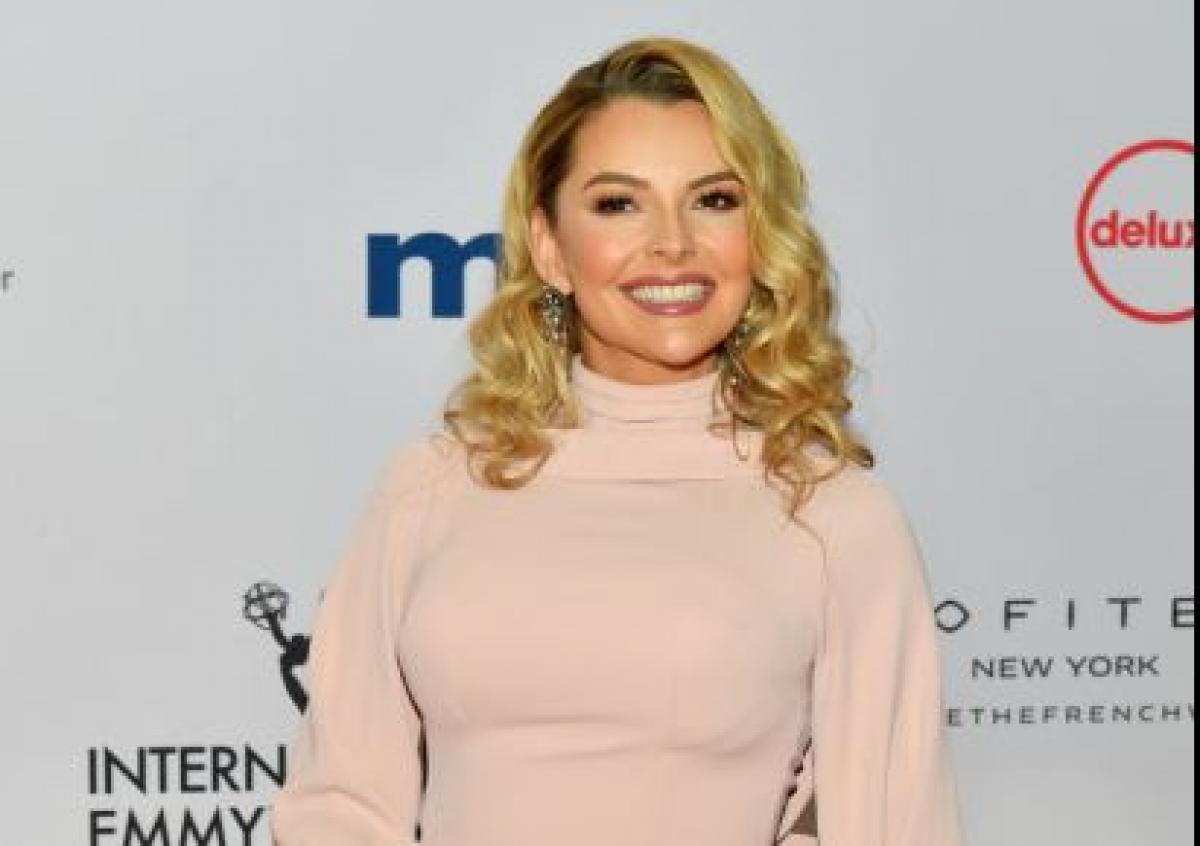 Marjorie De Sousa poartă o rochie roz și are părul desprins. Actrița are un machiaj natural