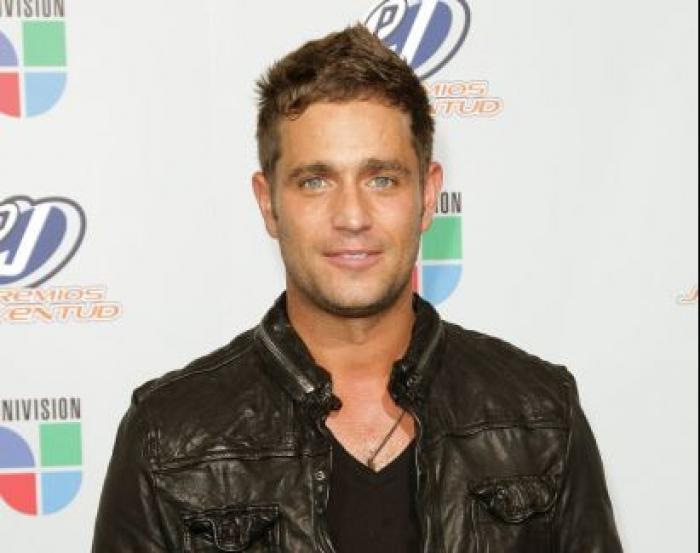 Michel Brown poartă un tricou negru și o geacă de piele