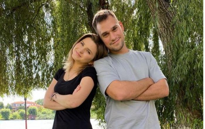 Cristina Ciobănașu este îmbrăcată într-un tricou negru și blugi, iar Vlad Gherman într-un tricou albastru deschis și pantaloni scurți