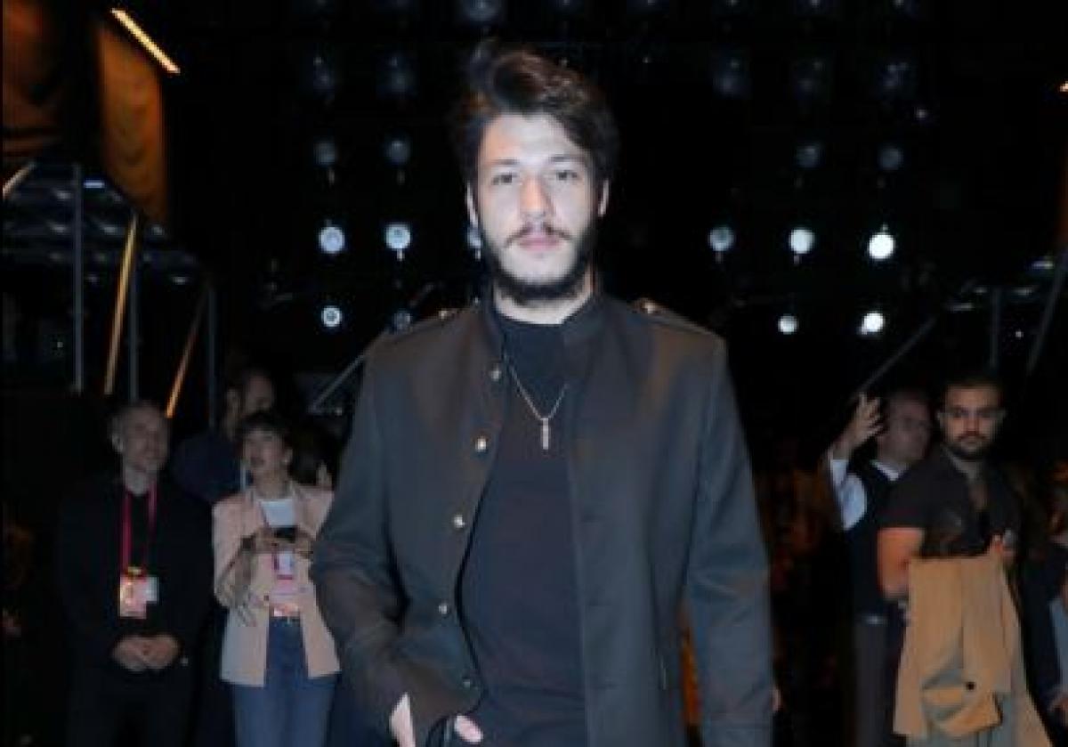 Kubilay Aka poartă un tricou negru și o geacă de piele de aceeași culoare