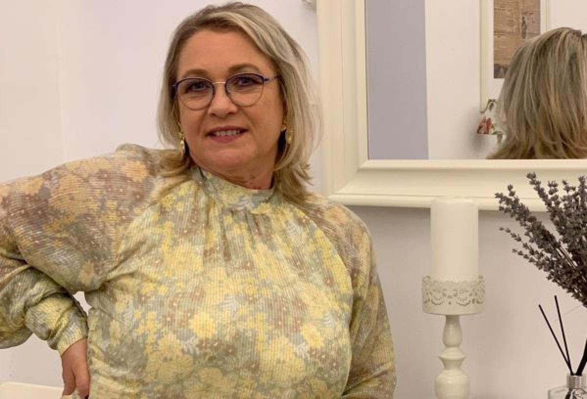 Georgeta Bucur este îmbrăcată cu o rochie cu flori și poartă ochelari de vedere