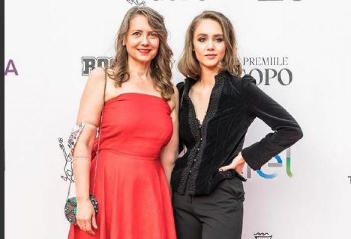 Ioana Abur este îmbrăcată într-o rochie roșie, iar Teona poartă o ținută all-black