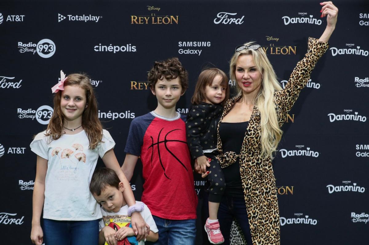 Michelle Vieth poartă blugi, un maiou albastru închis și un palton animal print