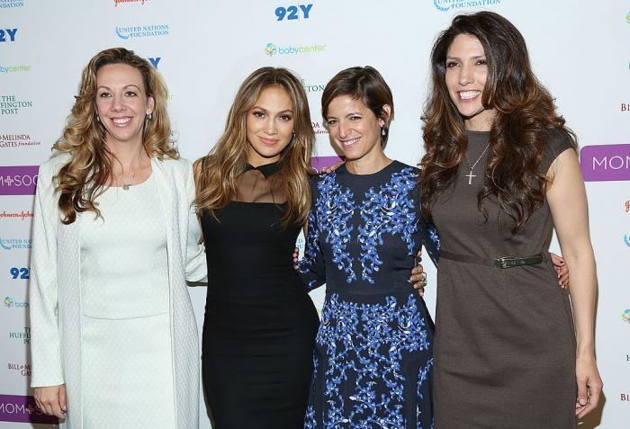 Jennifer Lopez poartă o rochie neagră și are părul desprins, iar Lynda Lopez poartă o rochie maro cu mâneci scurte