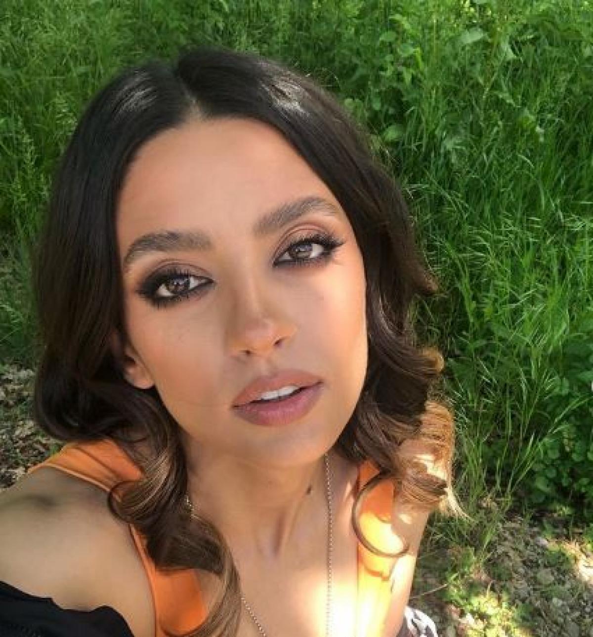 Oana Moșneagu poartă părul ondulat și este machiată