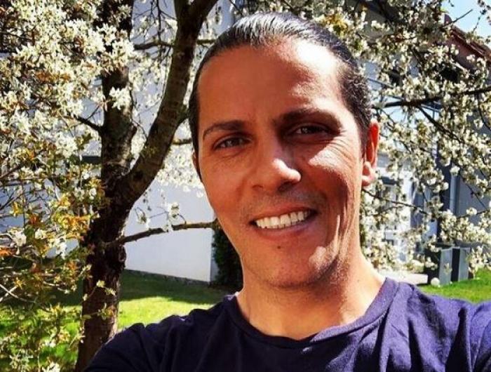 Lucian Viziru poartă părul lung și prins într-un coc. Actorul are un tricou mov