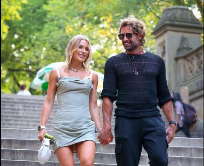 Gabriel Soto poartă pantaloni închiși la culoare și o bluză cu mâneci lungi, dar și ochelari de soare. Irina Baeva este îmbrăcată într-o rochie scută și are părul blond, desprins