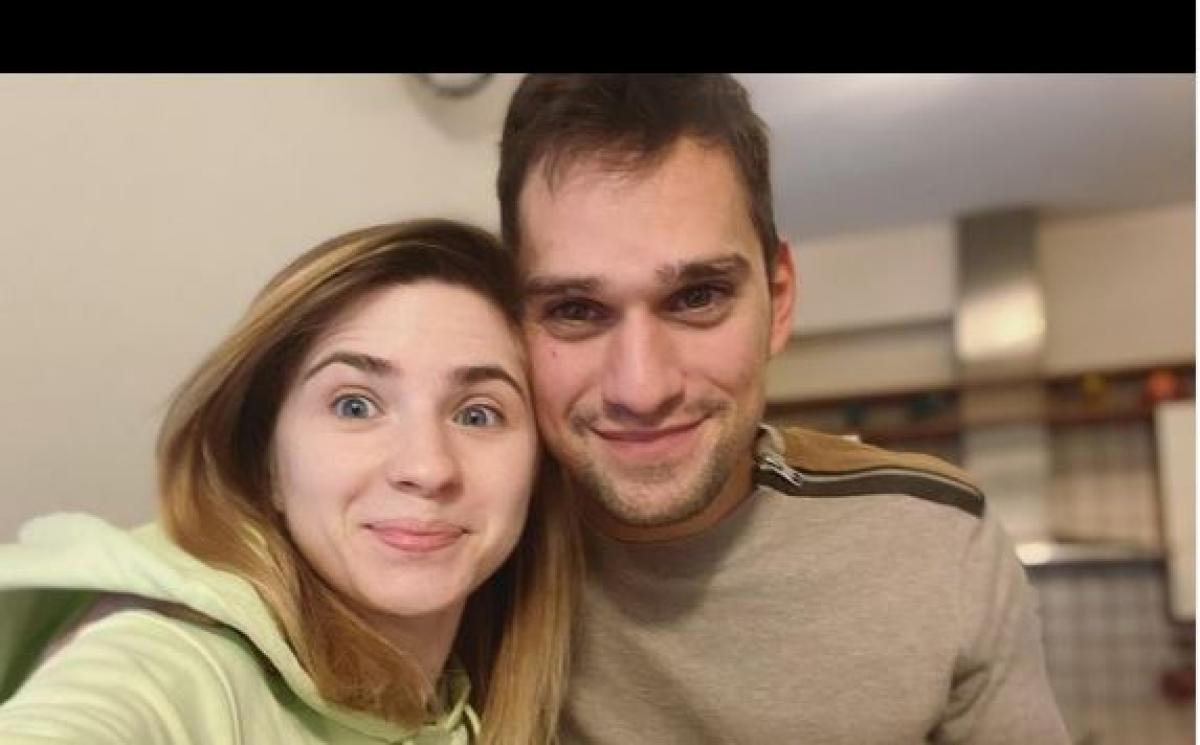 Cristina Ciobănașu poartă un hanorac verde și are părul desprins, iar Vlad poartă o bluză maro deschis