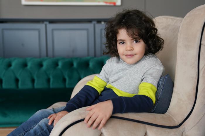 Berat Ruzgar Ozkan poartă un pulover gri cu albastru și verde fosforescent