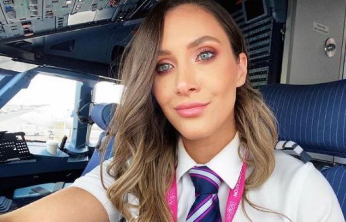 Andreea Lițescu poartă părul desprins și ondulat și este îmbrăcată cu uniforma de pilot