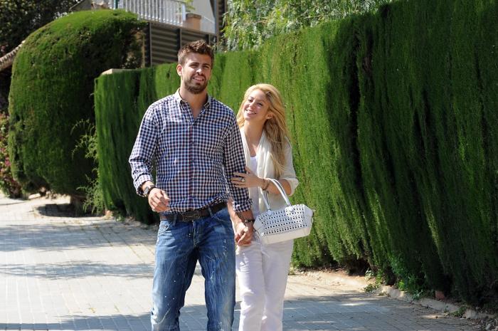 Shakira este îmbrăcată în alb și îl ține de braț pe iubitul ei, Pique. Bărbatul poartă blugi și o cămașă