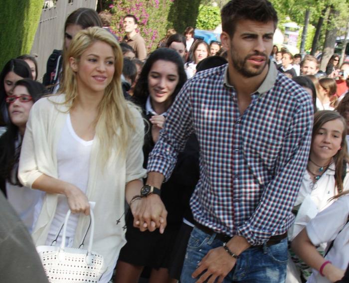 Shakira este îmbrăcată în alb și îl ține de mână pe iubitul ei, Pique