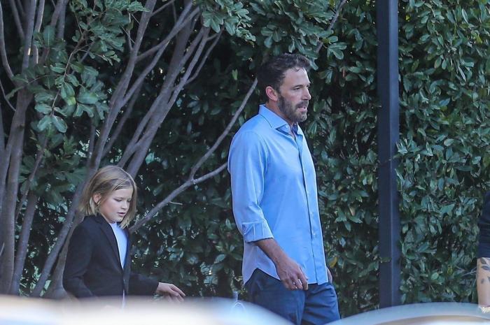 Ben Affleck poartă blugi și o cămașă albastră