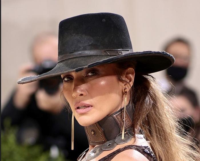 Jennifer Lopez poartă o pălărie cu boruri largi și are un machiaj de seară