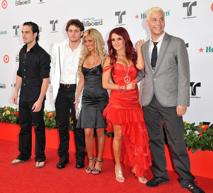 Dulce Maria, alături de ceilalți membri ai trupei RBD îmbrăcată într-o rochie lungă, roșie