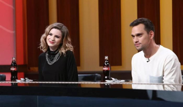 Criss poartă o bluză neagră și are părul desprins și ondulat, iar Vlad Gherman poartă o bluză albă cu mâneci lungi